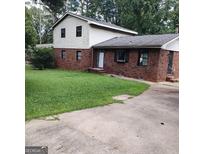 Two-story home with brick and white siding and a green lawn and concrete driveway at 1217 Dove Ct, Morrow, GA 30260