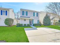 Charming two-story home with a well-maintained lawn and concrete driveway on a sunny day at 371 Coral Cir, Mcdonough, GA 30253