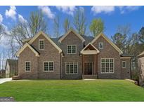 Elegant brick home boasts lush lawn, symmetrical design, and inviting covered entryway at 5265 Brookhollow Dr, Douglasville, GA 30135