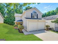 Charming two-story home with manicured lawn, lush landscaping, and two-car garage at 2940 Highland Hill Pkwy, Douglasville, GA 30135