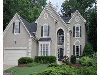 Charming two-story home featuring traditional architectural details and manicured landscaping at 5860 Fairway View Dr, Suwanee, GA 30024