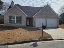 Charming brick home with a well-maintained yard and attached two-car garage at 1354 Persimmon Ct, Lithonia, GA 30058
