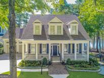 Charming two-story home with a welcoming front porch, well-manicured lawn, and mature trees at 504 Telfair Park, Peachtree City, GA 30269