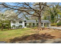 Charming home with landscaped front yard, covered parking, and black framed windows, creating a welcoming curb appeal at 1146 Redan Way, Stone Mountain, GA 30088
