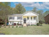 Charming split-level home features a welcoming front porch, tidy landscaping, and a sunny facade at 319 Honeysuckle Ter, Auburn, GA 30011