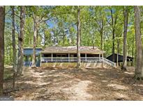 Charming single-story home with a welcoming front porch and lush, wooded surroundings at 1597 Leguin Mill Rd, Locust Grove, GA 30248