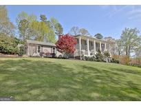 Stately two-story home with manicured lawn and a beautiful, columned front porch at 100 Smokerise Trce, Peachtree City, GA 30269