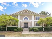 Stately two-story home featuring a symmetrical facade, manicured landscaping, and elegant double door entry at 7415 Northampton Ct, Cumming, GA 30040