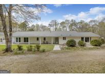 Ranch-style home with a covered front porch, manicured landscaping, and a gravel driveway at 12435 Hamilton Rd # 536/- Ac, Chattahoochee Hills, GA 30268