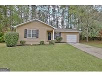 Charming single-story home featuring a well-manicured lawn and cozy curb appeal at 212 Bella Rosa, Peachtree City, GA 30269