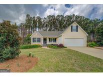 Charming home with manicured lawn, lush landscaping, and inviting front porch at 116 Laurel Ln, Social Circle, GA 30025