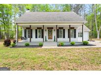 Charming single-story home with a welcoming front porch and beautiful landscaping at 105 Honey Creek Rd, Mcdonough, GA 30252