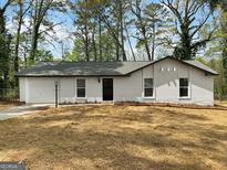 Charming single-story home with a white brick facade, attached garage, and a freshly mulched front yard at 2800 Chelsey Trl, Jonesboro, GA 30236