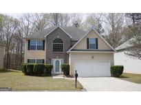 Charming two-story home with a brick accent, attached garage, and manicured front yard at 2210 Benidorm Ct, South Fulton, GA 30349
