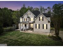 Elegant two-story home featuring traditional architecture, manicured lawn, and inviting entryway with landscaped garden at 70 Barrington Farms Ct, Sharpsburg, GA 30277