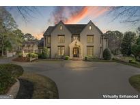 Stately home with a circular driveway, manicured landscaping, and elegant architectural details at 140 Newhaven Dr, Fayetteville, GA 30215