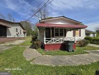 A small single Gathering home with red awning over the porch at 1243 Hill Nw St, Conyers, GA 30012