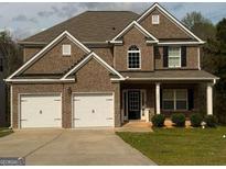 Charming two-story brick home with a well-maintained lawn and a two-car garage at 1461 Judson Way, Riverdale, GA 30296