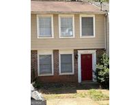 A charming townhouse with a red front door and neutral-toned siding, enhancing curb appeal at 5575 Marbut Rd, Lithonia, GA 30058