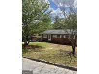 Charming brick home featuring a covered carport and a well-maintained front yard with mature trees at 1079 Pine Ne St, Conyers, GA 30012
