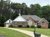 Charming single-story brick home featuring a well-manicured lawn and an attached two-car garage at 5003 Samantha Ct, Mcdonough, GA 30252