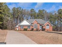 Charming brick home featuring a well-manicured lawn, mature trees, and a welcoming entrance at 5003 Samantha Ct, Mcdonough, GA 30252