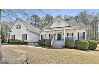 Charming white two-story home with a welcoming front porch and manicured landscaping at 35 Ryans Ct, Sharpsburg, GA 30277