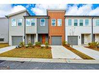 Charming townhome featuring a well-manicured lawn and a gray garage door, inviting and stylish curb appeal at 1516 Parks Edge Nw Ln, Atlanta, GA 30318