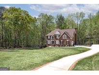 Beautiful brick two-story home with a well-manicured lawn and long driveway at 20 Allie Dr, Mcdonough, GA 30252