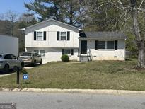 Charming two-story home with black shutters and a well-maintained front yard in a suburban neighborhood at 579 Wexwood Dr, Riverdale, GA 30274