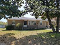 Charming one-story home with tan siding, mature trees, and a welcoming front porch at 4365 Newton Cir, Douglasville, GA 30134