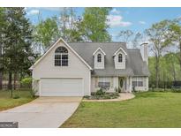 Charming home with a two-car garage, dormer windows, and a well-maintained lawn with mature trees at 2014 Big Cypress Ln, Locust Grove, GA 30248