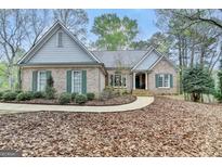 Charming brick home featuring a manicured lawn, symmetrical shutters, and a welcoming front entrance at 3230 Riverhill Ct, Cumming, GA 30041