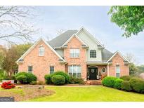 Beautiful brick two-story home with a manicured lawn and mature landscaping creating an inviting curb appeal at 101 Westminster Way, Mcdonough, GA 30253