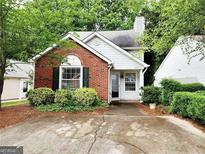 Charming home featuring brick accents, manicured landscaping, and inviting curb appeal in a tranquil neighborhood setting at 645 Crossbridge Aly, Johns Creek, GA 30022