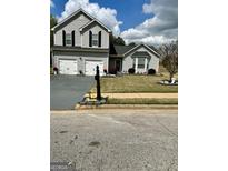 Charming two-story home featuring a two-car garage, well-maintained lawn, and inviting curb appeal at 55 Long Dr, Covington, GA 30016