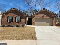 Charming brick home featuring a well-manicured lawn and a two-car garage at 4090 Spencer Ln, Stonecrest, GA 30038