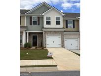New townhome featuring a brick front, attached garage, driveway, and lawn at 8726 Lakeview Commons # 50, Jonesboro, GA 30238