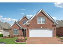 Beautiful two-story brick home featuring a brick driveway and an attached two-car garage at 1570 Woodberry Run Dr, Snellville, GA 30078