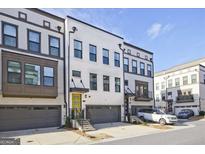 Modern townhome with a yellow door, gray garage, and professional landscaping at 1149 Ansel Nw Ln, Atlanta, GA 30318