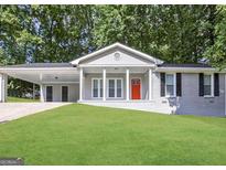 Charming single-story home featuring a covered carport, a red front door, and a well-maintained lawn at 2942 Elkhorn Ct, Decatur, GA 30034