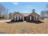 Charming single-story home with a well-maintained front yard and a mix of vinyl siding and brick facade at 321 Harris Ave, Locust Grove, GA 30248