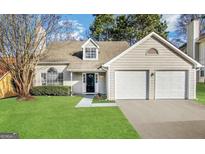 Charming one-story home featuring a two-car garage, well-maintained lawn, and traditional architectural details at 3228 Rivermist Cv, Decatur, GA 30034