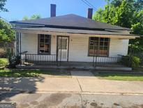 Quaint single-story home featuring a covered front porch, a simple yard, and a vintage charm at 34 Pine St, Porterdale, GA 30014