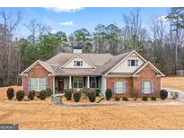Charming brick home with a well-manicured lawn and symmetrical landscaping, perfect for curb appeal at 144 Caraway Rd, Locust Grove, GA 30248