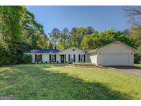 Charming single-story home featuring a manicured lawn and attached two-car garage, perfect for suburban living at 2340 Rolling Acres Sw Dr, Conyers, GA 30094
