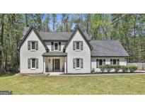 Charming two-story home featuring a grey roof, white brick facade, and well-manicured front yard at 214 Windgate Ct, Peachtree City, GA 30269