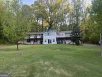 Charming multi-story home boasting a large yard, mature trees, and a full length balcony at 2316 Emerald Dr, Jonesboro, GA 30236