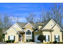 Charming home with stone and stucco exterior, arched window, manicured landscaping, and a well-maintained yard at 725 White Dove Dr, Mcdonough, GA 30253