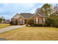 Charming single-story brick home with well-manicured lawn and a paved driveway leading to a welcoming entrance at 118 Jasmine Way, Villa Rica, GA 30180